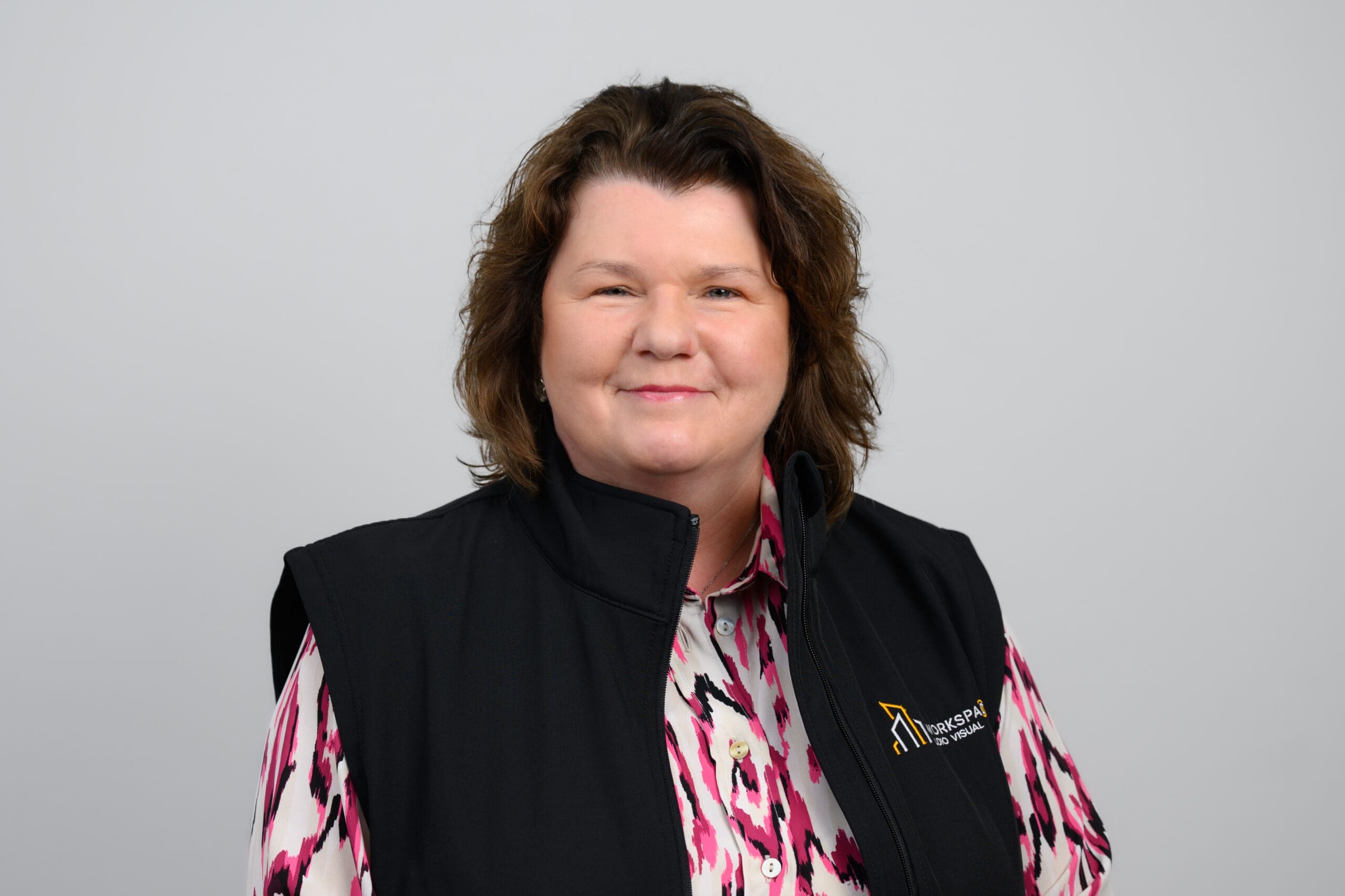 woman in a black vest and pink and white shirt